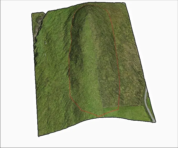 3D model of a long grassy mound on a hillside, with its base outlined in red.